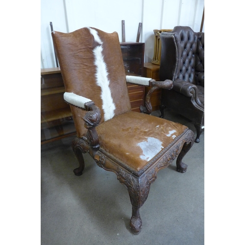 31 - A pair of American Chippendale style carved mahogany and cow hide armchairs (one a/f)