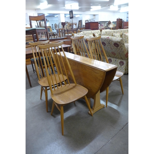 33 - An Ercol Blonde elm and beech drop leaf dining table and a set of four Goldsmith chairs