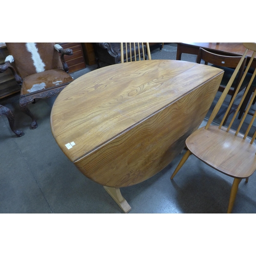 33 - An Ercol Blonde elm and beech drop leaf dining table and a set of four Goldsmith chairs