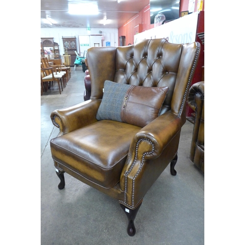 7 - A Chesterfield brown leather three piece lounge suite, comprising; sofabed settee, wingback armchair... 