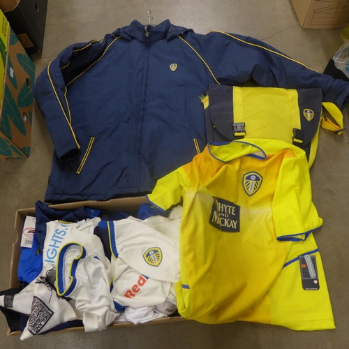 A collection of Leeds United football shirts, a bag, three Leeds Rhinos