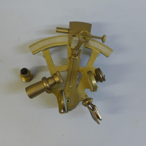 673 - A small brass sextant, one blue glass lens loose