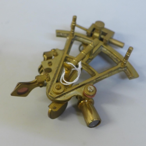 673 - A small brass sextant, one blue glass lens loose