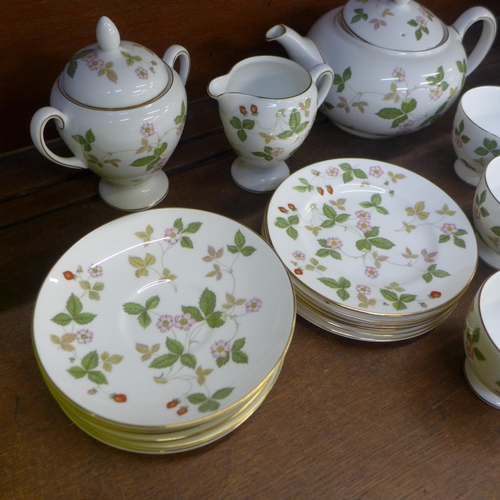 701 - A Wedgwood Wild Strawberry tea set, six settings with sugar pot and cream jug