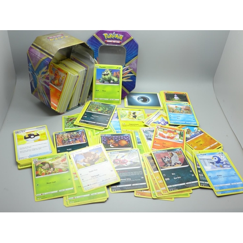 844 - Thirty Holo/reverse Holo and 300 common/uncommon/rare Pokemon cards in tin