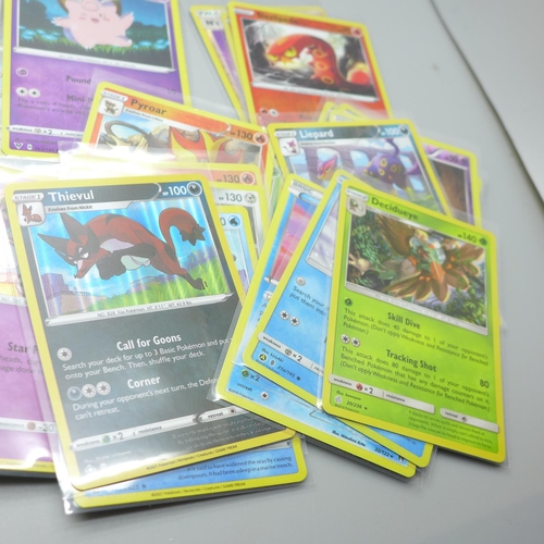 845 - Thirty Holo/reverse Holo and 300 common/uncommon/rare Pokemon cards, in tin