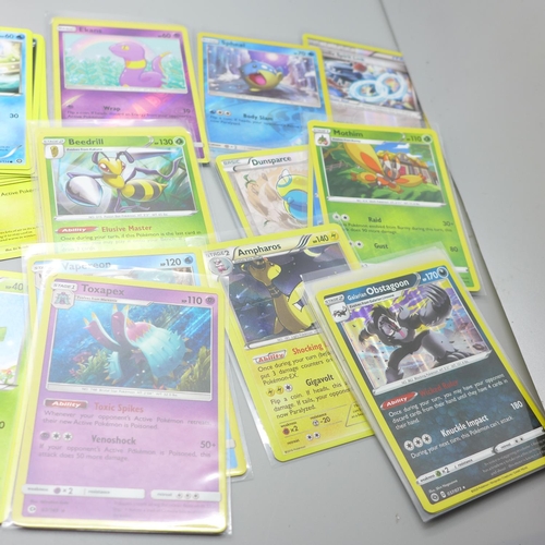 847 - Thirty Holo/reverse Holo and 300 common/uncommon/rare Pokemon cards, in tin