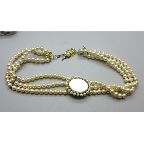 865 - A silver buckle bangle, a goldstone pendant and a simulated pearl necklace