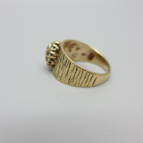 1090 - A 9ct gold ring with bark effect design and garnet cluster,  makers mark S&Co, shank split, 4.8g, P