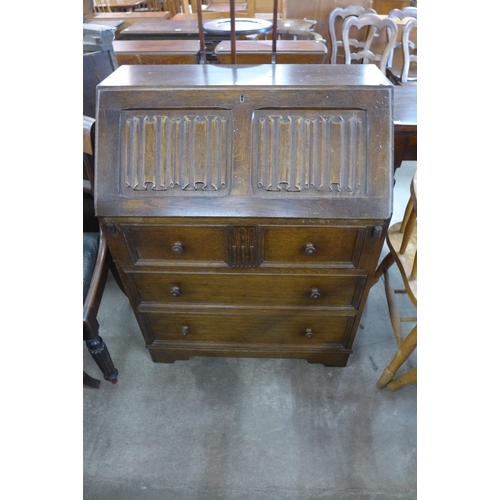 169 - A carved oak linenfold bureau