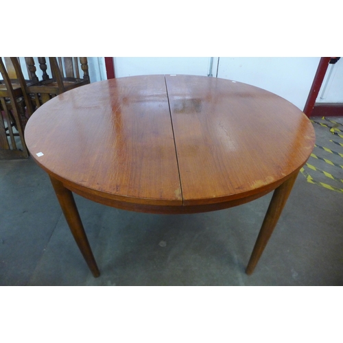 20 - A teak circular extending dining table