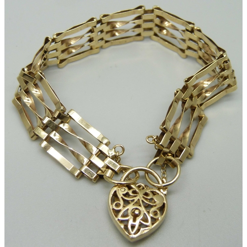 1035 - A 9ct gold gate bracelet with fretwork padlock clasp, 10.4g