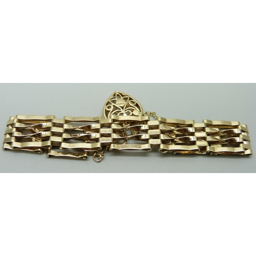 1035 - A 9ct gold gate bracelet with fretwork padlock clasp, 10.4g