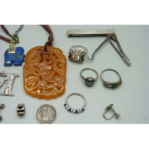 1041 - A yellow metal mounted lapis lasuli pendant in the form of an elephant, silver rings, a silver 'M' p... 