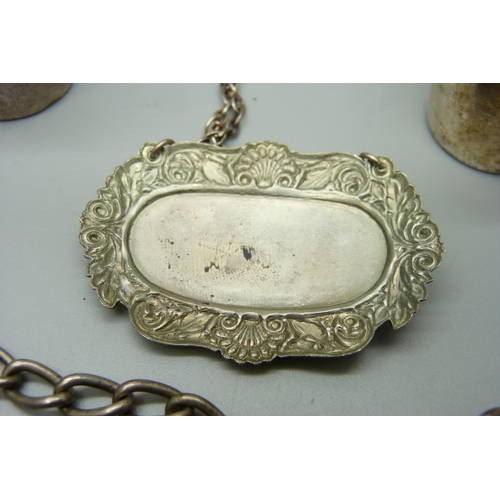 1058 - A silver brandy label, a silver Albert chain with base metal dog clip and T bar, and two white metal... 