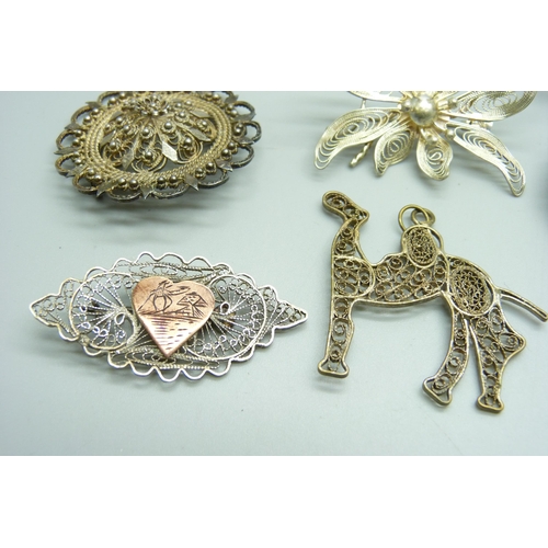 1062 - Nine silver and white metal brooches and a pendant, 56g