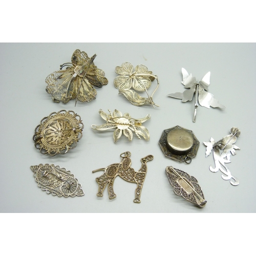 1062 - Nine silver and white metal brooches and a pendant, 56g