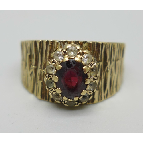 1090 - A 9ct gold ring with bark effect design and garnet cluster,  makers mark S&Co, shank split, 4.8g, P