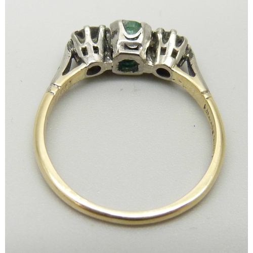 1161 - An 18ct gold and platinum ring set with a central emerald and two diamonds, 2.7g, P