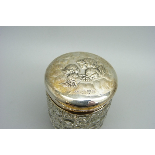 1172 - A silver topped jar decorated with Reynolds Angels, Chester 1905 and two silver mounted combs