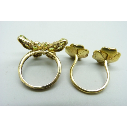 1198 - A silver gilt and peridot butterfly ring and a flower style ring