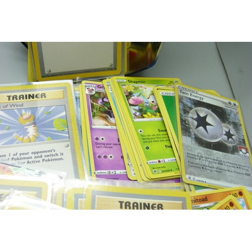 863 - Two tins of assorted Pokemon cards including holos