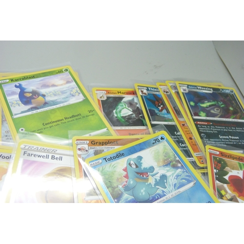 864 - Thirty holo/reverse holo and 300 common/uncommon/rare Pokemon cards in tin