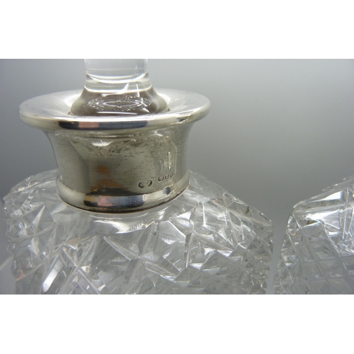 867 - A pair of silver rimmed cut glass crystal decanters