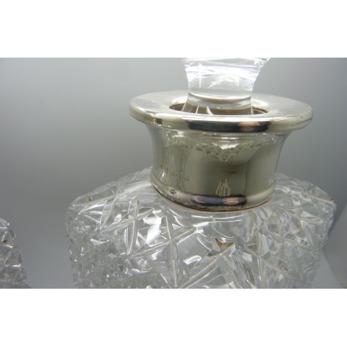 867 - A pair of silver rimmed cut glass crystal decanters