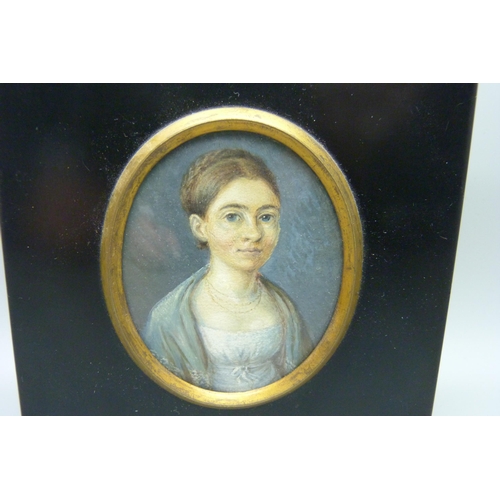 932 - A 19th Century portrait miniature on card, in an ebonised frame with acorn hanger