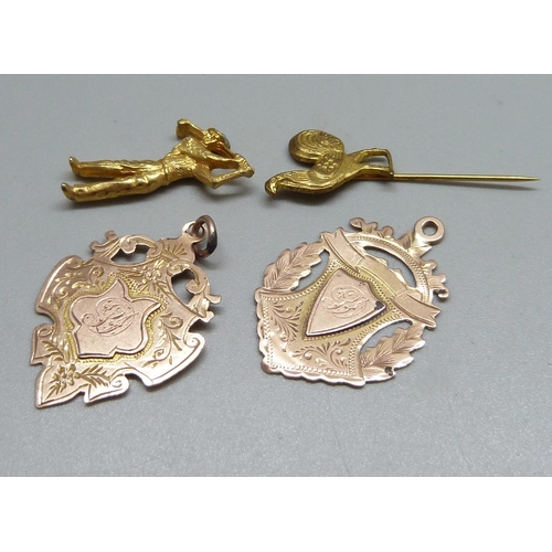 999 - Two 9ct gold fobs, 5.3g, a miniature metal figure and a stick pin