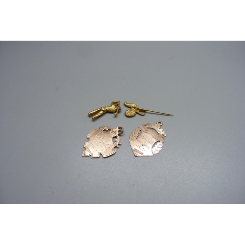 999 - Two 9ct gold fobs, 5.3g, a miniature metal figure and a stick pin