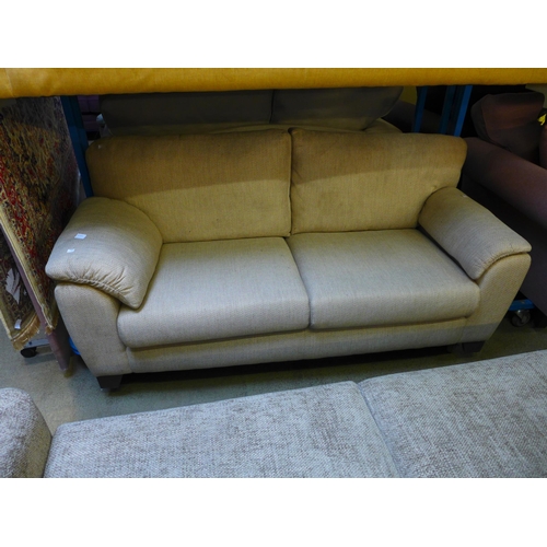 1605 - A sand upholstered three seater sofa - marked