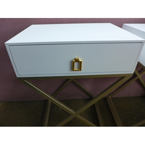 1434 - A pair of white bedside tables with cross legs, slight damage