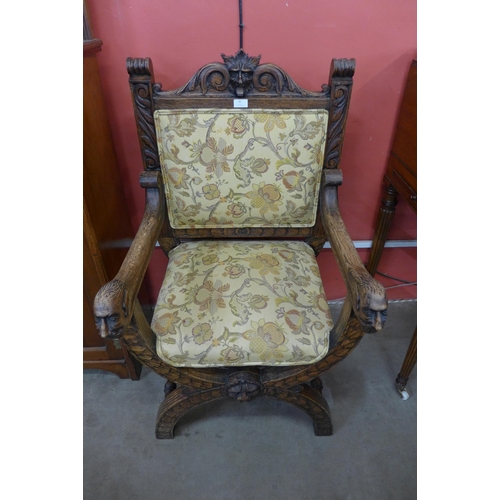 132 - A 17th Century style carved oak and fabric upholstered green man x-frame chair