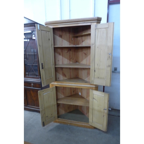 222 - A George III style pine freestanding corner cupboard