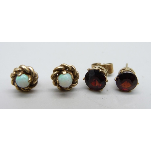 1027 - A pair of yellow metal and opal ear studs and a pair of yellow metal and garnet ear studs, total wei... 