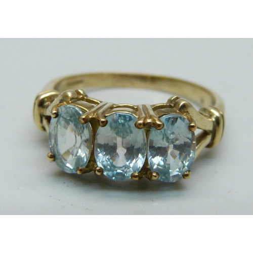 1051 - A 9ct gold aquamarine trilogy ring, 4g, S