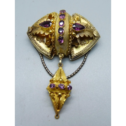 1087 - A Victorian yellow metal brooch set with amethysts, (tests as 14ct gold), with a case, 8.5g