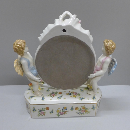 603 - A continental porcelain cherub table mirror, 27.5cm