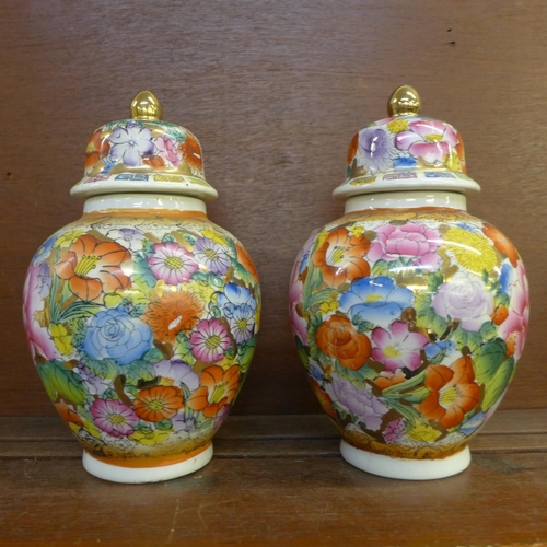 605 - A pair of oriental lidded vases, 23cm