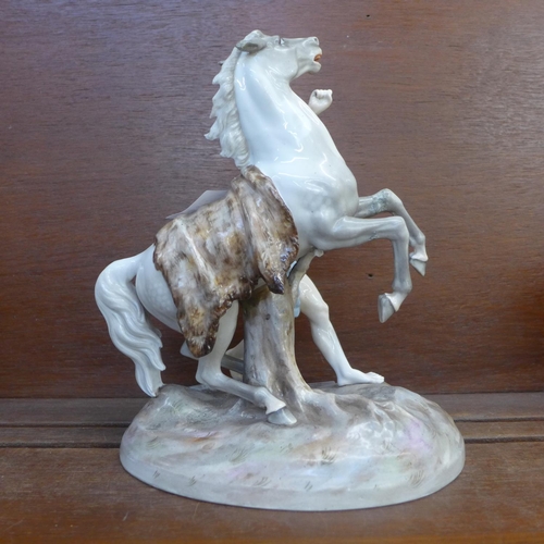 606 - A continental porcelain figure of a man and a horse, horse leg a/f