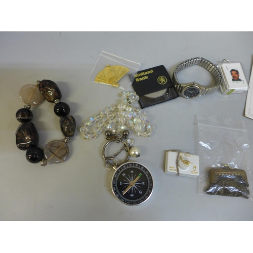 635 - A bag of miscellaneous items including miniature chain metal purse, crowns, bracelets, etc.