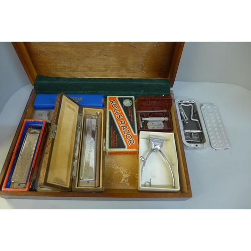 670 - A case containing Rolls razors and three harmonicas, includes Hohner 64 Chromonica