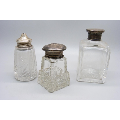 854 - A hallmarked silver topped salt pot and two silver topped scent bottles, (one is hallmarked, the oth... 