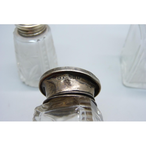 854 - A hallmarked silver topped salt pot and two silver topped scent bottles, (one is hallmarked, the oth... 