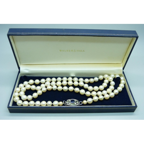 856 - A long string of large cultured pearls on a silver and paste clasp, approximately 82cm long, pearls ... 