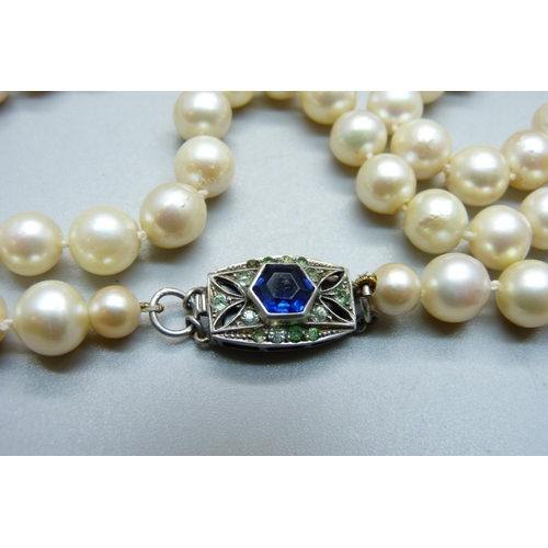 856 - A long string of large cultured pearls on a silver and paste clasp, approximately 82cm long, pearls ... 