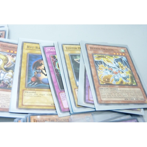 877 - Yu-Gi-Oh cards including holos and dragon cards in protective sleeves