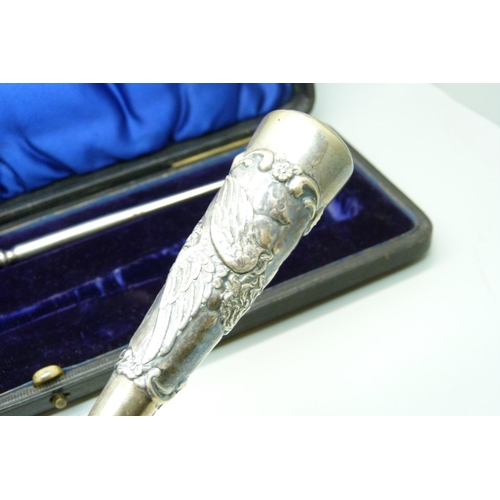 919 - A cased silver handled shoe horn and boot pull with Reynold's Angels decoration